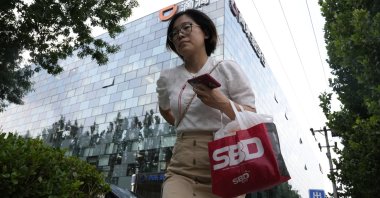 A woman passes by the Didi headquarters in Beijing, China, July 16, 2021. (AP Photo)
