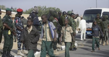 A group of schoolboys are escorted by Nigerian military and officials following their release after they were kidnapped, in Katsina, Nigeria, Dec. 18, 2020. (AP Photo)