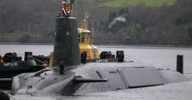 A crew from HMS Vengeance, a British Royal Navy Vanguard class Trident Ballistic Missile Submarine, stand on their vessel as they return along the Clyde river to the Faslane naval base near Glasgow, Scotland, Dec. 4, 2006. (Reuters Photo)