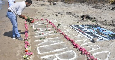 A man lays down flowers to commemorate Syrian toddler Aylan Kurdi in Fener Burnu district, Muğla province, Turkey, Sept. 10, 2019. (AA File Photo)