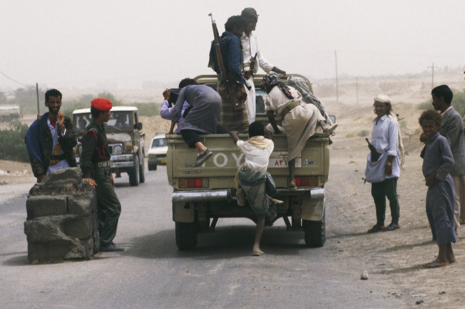 Soldiers guard the main road through Marib as locals hop on and off trucks passing through town, Marib, Yemen, April 1995. (Getty Images)