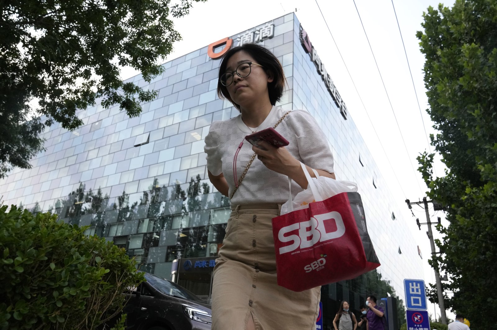 A woman passes by the Didi headquarters in Beijing, China, July 16, 2021. (AP Photo)