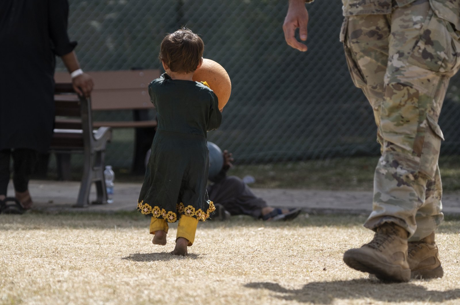 A child plays with a ball at the Sigonella NATO air base, Italy, Sept. 1, 2021. (AP Photo)
