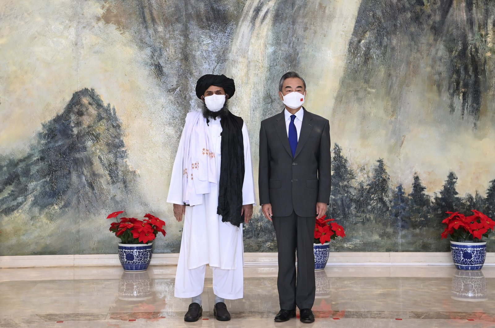 In this photo released by China's Xinhua News Agency, Taliban co-founder Mullah Abdul Ghani Baradar (L) and Chinese Foreign Minister Wang Yi pose for a photo during their meeting in Tianjin, China, July 28, 2021. (Li Ran / Xinhua via AP File Photo)