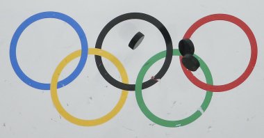 Hockey pucks bounce off the wall during the warm-up session before the USA vs Finland men's bronze medal ice hockey game at the 2014 Winter Olympics in Sochi, Russia, Feb. 22, 2014. (AP File Photo) 