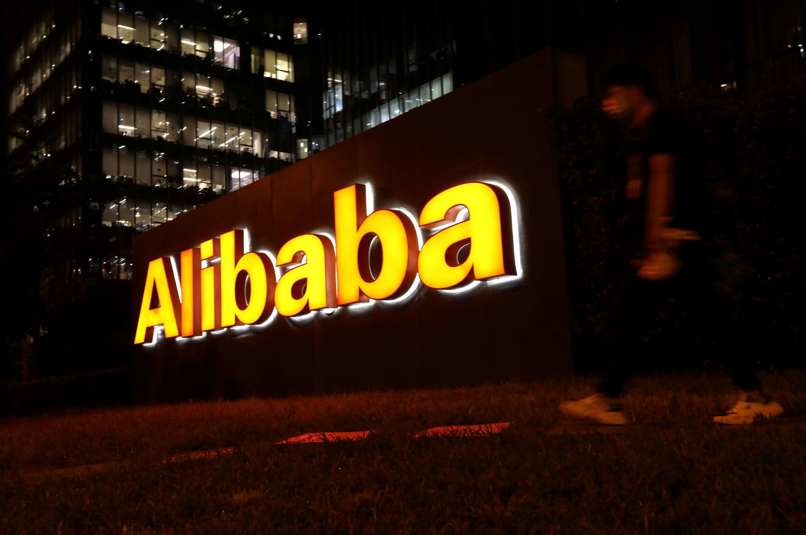 A man walks past a logo of Alibaba Group at its office building in Beijing, China, Aug. 9, 2021. (Reuters Photo)