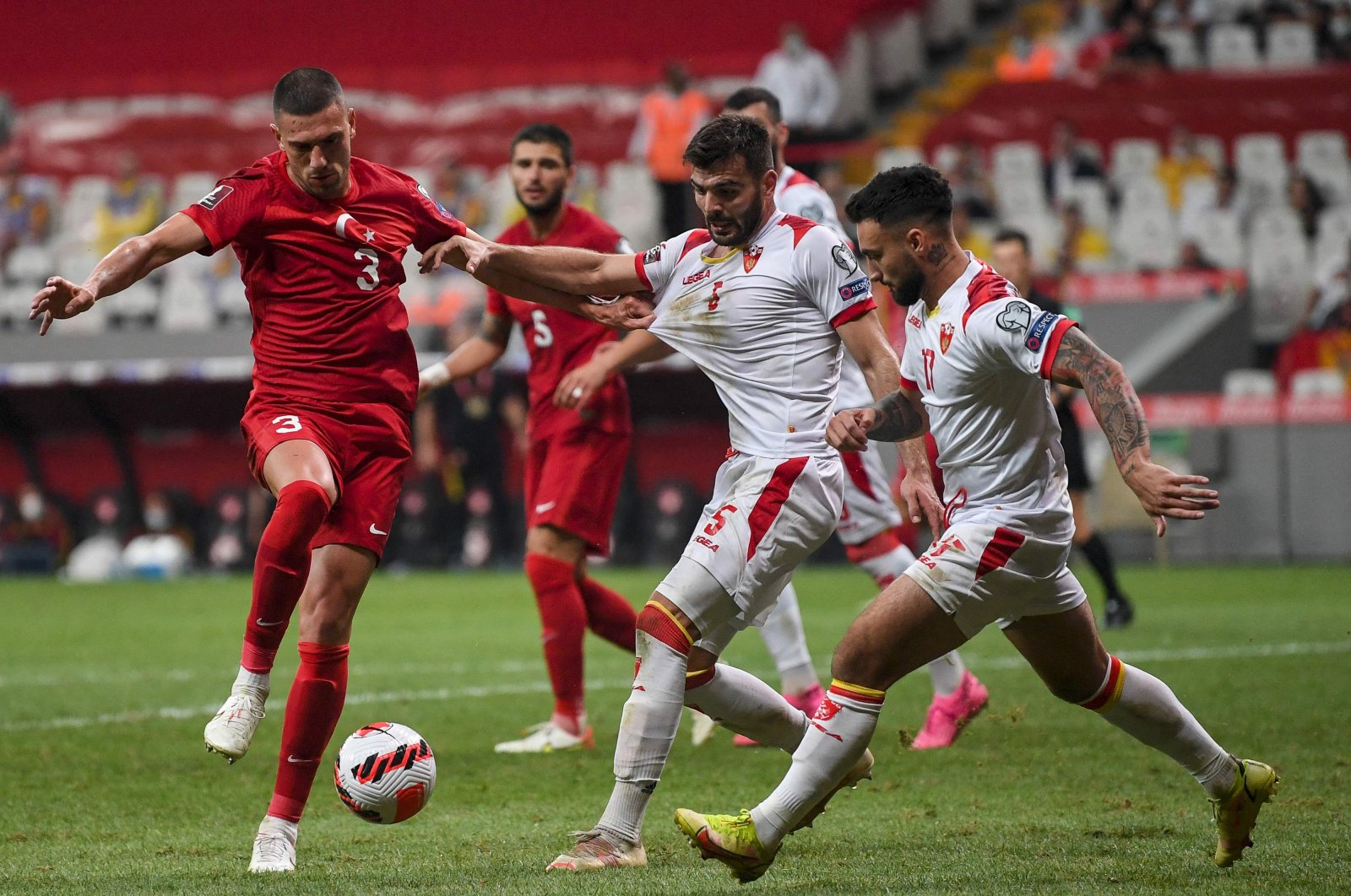 Turkey defender Merih Demiral (L) fights for the ball with Montenegro's Igor Vujacic (C) and Stefan Savic (R) during their FIFA World Cup Qatar 2022 qualifier at the Vodafone Stadium, Istanbul, Turkey, Sept. 1, 2021. (AFP Photo)