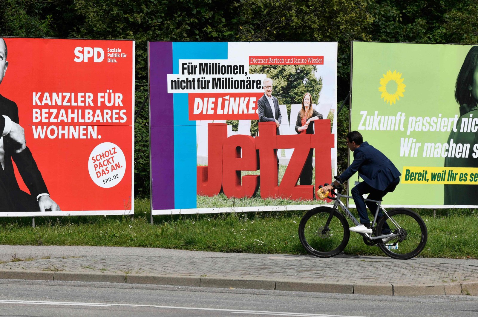 German Finance Minister, Vice-Chancellor and Social Democratic Party's (SPD) candidate for chancellor Olaf Scholz (L), Greens party co-leader and candidate for chancellor Annalena Baerbock (R) and a poster of Germany's left party Die Linke (C) in Stuttgart, southern Germany, Sept. 1, 2021, ahead of parliamentary elections on Sept. 26. (AFP Photo)