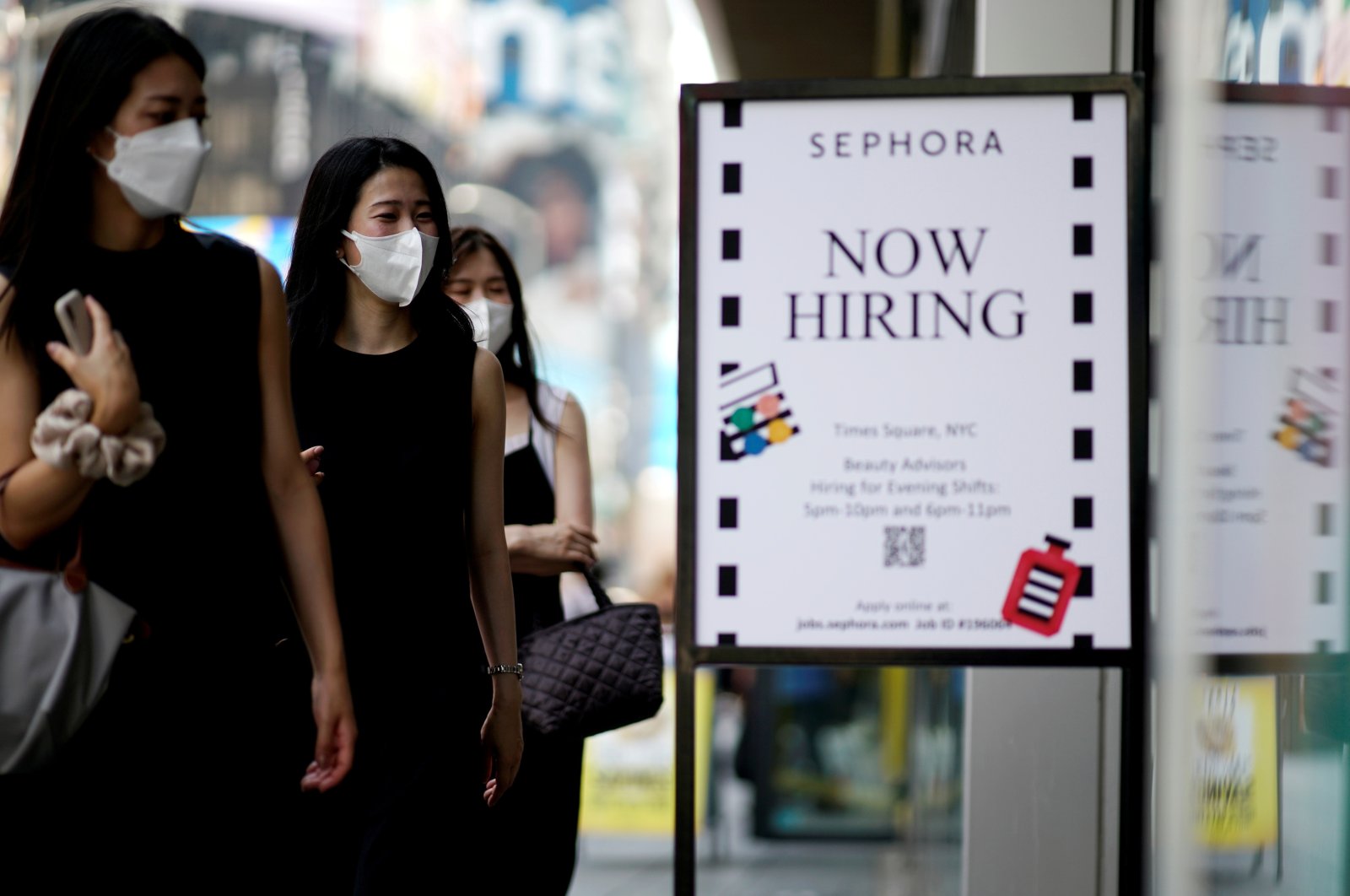 A sign advertising job openings is seen while people walk into a store in New York City, New York, U.S., Aug. 6, 2021. (Reuters Photo)