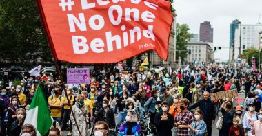 A demonstrator waves a flag reading "#leave No One Behind" during the "Unteilbar" demonstration in Berlin, Germany, Sept. 4, 2021. (EPA Photo)