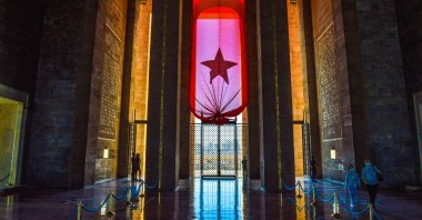 People wearing protective face masks walk past a giant Turkish national flag at Anıtkabir, the mausoleum of modern Turkey's founder Mustafa Kemal Atatürk, in Ankara, Turkey, Oct. 13, 2021. (Photo by Getty Images)