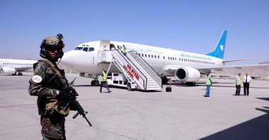 A member of Taliban forces stands guard next to a plane that has arrived from Kandahar at Kabul Hamid Karzai International Airport in Kabul, Afghanistan, Sept. 5, 2021. (Reuters Photo)