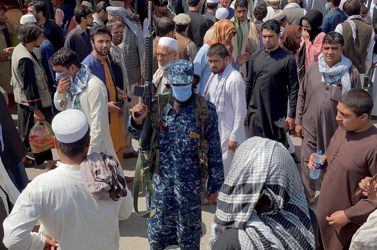 A Taliban security force member stands guard among crowds of people walking past in a street in Kabul, Afghanistan, Sept. 4, 2021. (Reuters Photo)