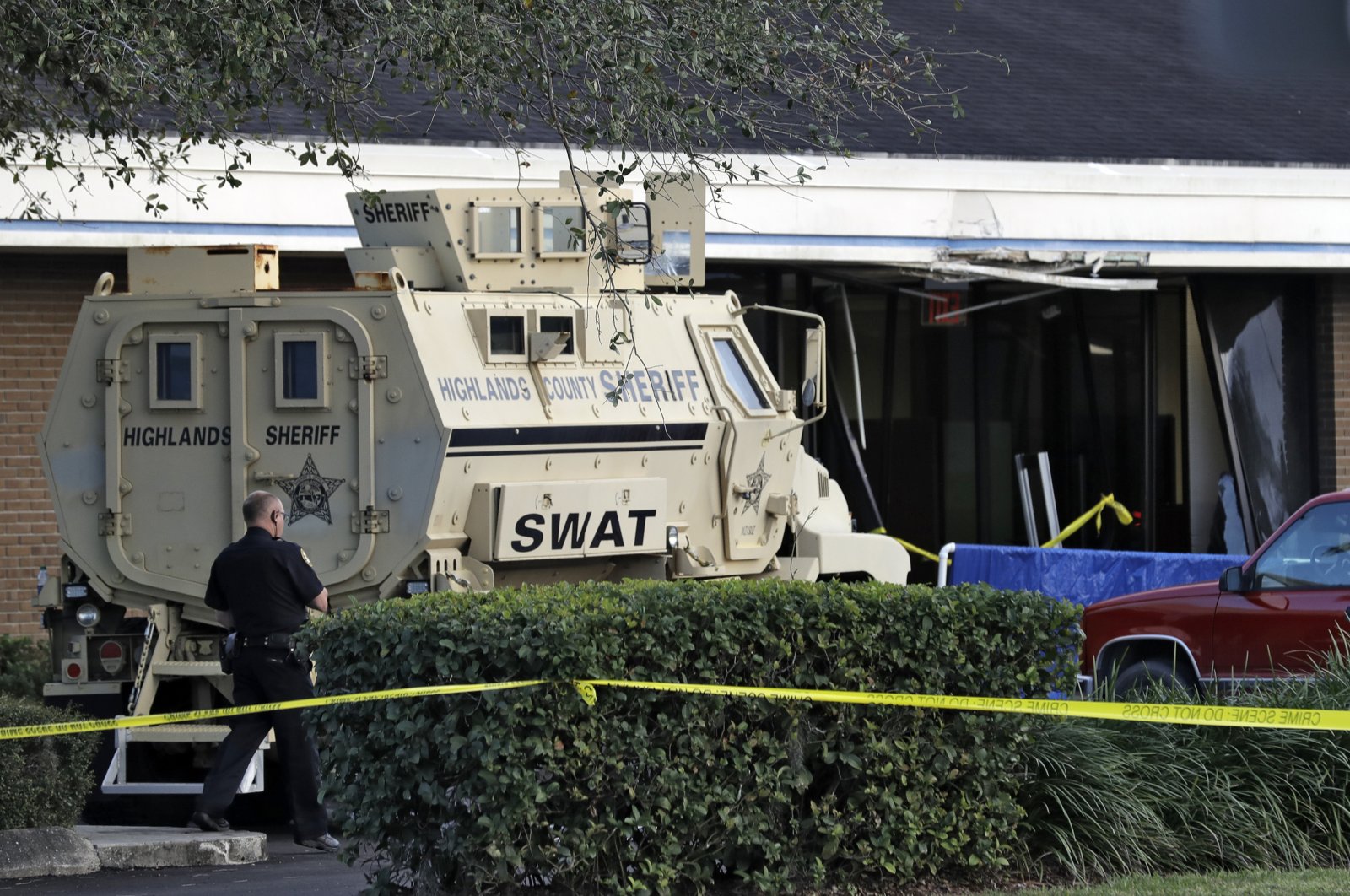 A police officer stands near a Highlands County Sheriff's SWAT vehicle that is stationed in front of a SunTrust Bank branch, Sebring, Florida, U.S., Jan. 23, 2019. (AP File Photo)