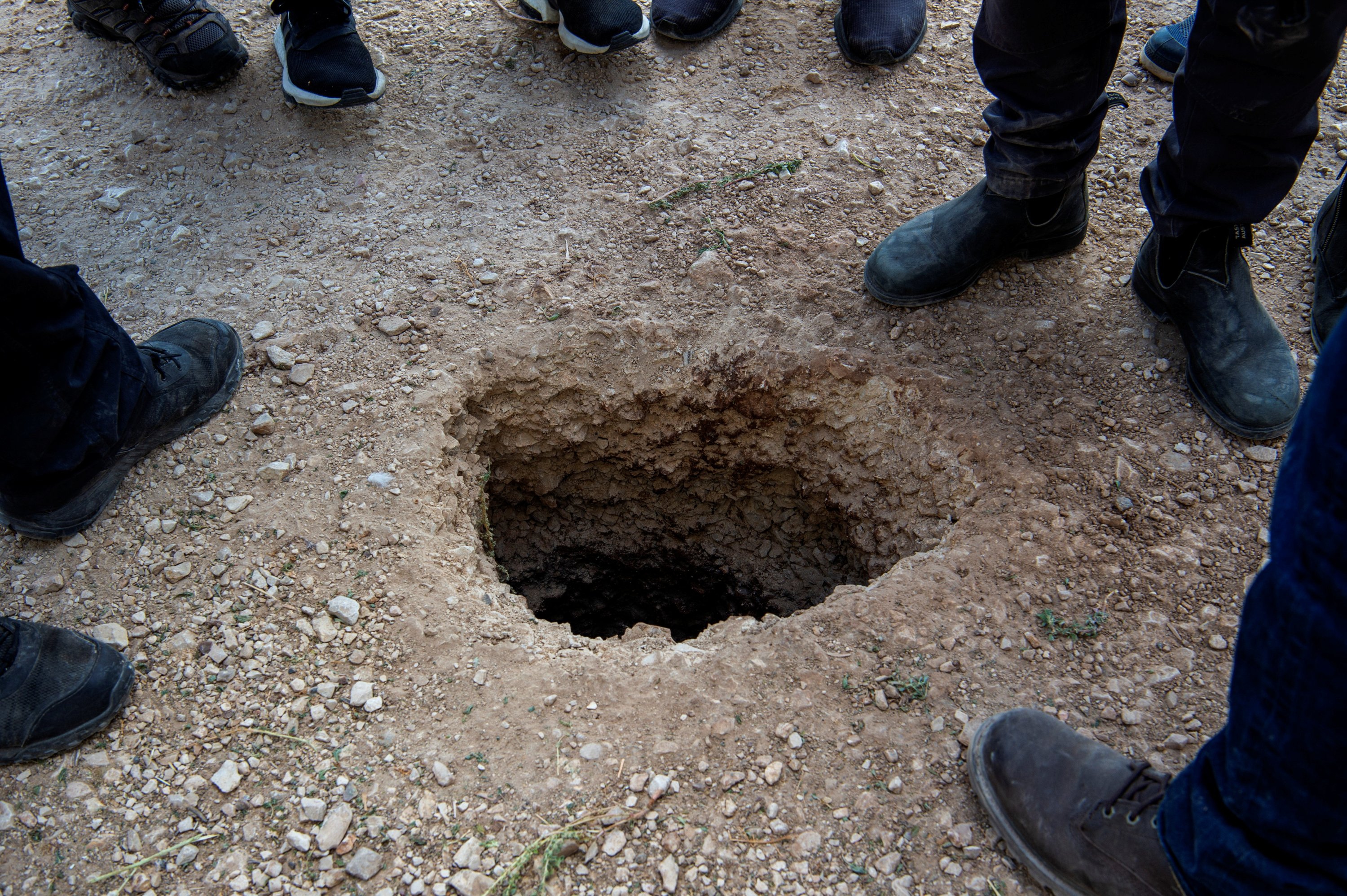 People stand by a hole in the ground outside the walls of Gilboa prison after six Palestinian militants broke out of it in north Israel September 6, 2021. (Reuters Photo)