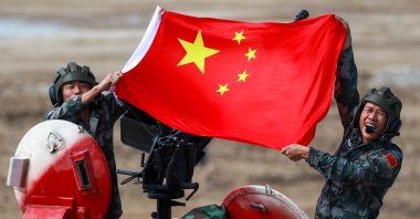 People's Liberation Army (PLA) soldiers pose with a Chinese flag on a TYPE 96B tank during the Tank Biathlon Contest at the 2021 International Army Games at a military training ground in Alabino, Moscow Region. (Sergei Fadeichev / TASS via Reuters)