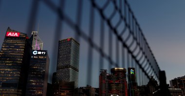 Skyscrapers at the central business district, including AIA Central, China Construction Bank (CCB) Tower, Bank of China Tower, Cheung Kong Centre, HSBC and Standard Chartered Bank headquarters, are seen through a fence during sunset in Hong Kong, Aug. 17, 2021. (Reuters Photo)