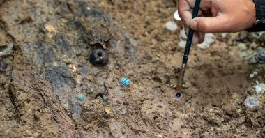 A restorer works at the Rheinisches Landesmuseum on beads made of glass and rock crystal that were recently found during a block salvage near Trier, Germany, June 23, 2021. (Getty Images)