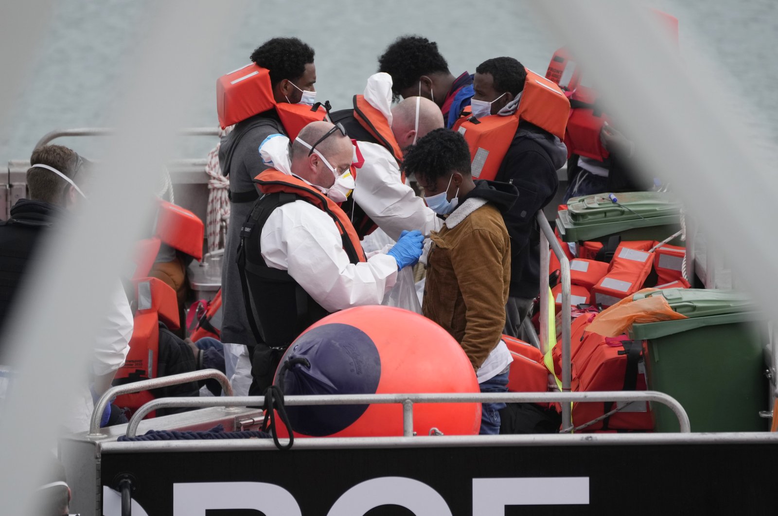 People thought to be migrants who made the crossing from France are disembarked after being picked up in the Channel by a British Border Force vessel in Dover, southeast England, Aug. 13, 2021. (Photo by Matt Dunham via AP)