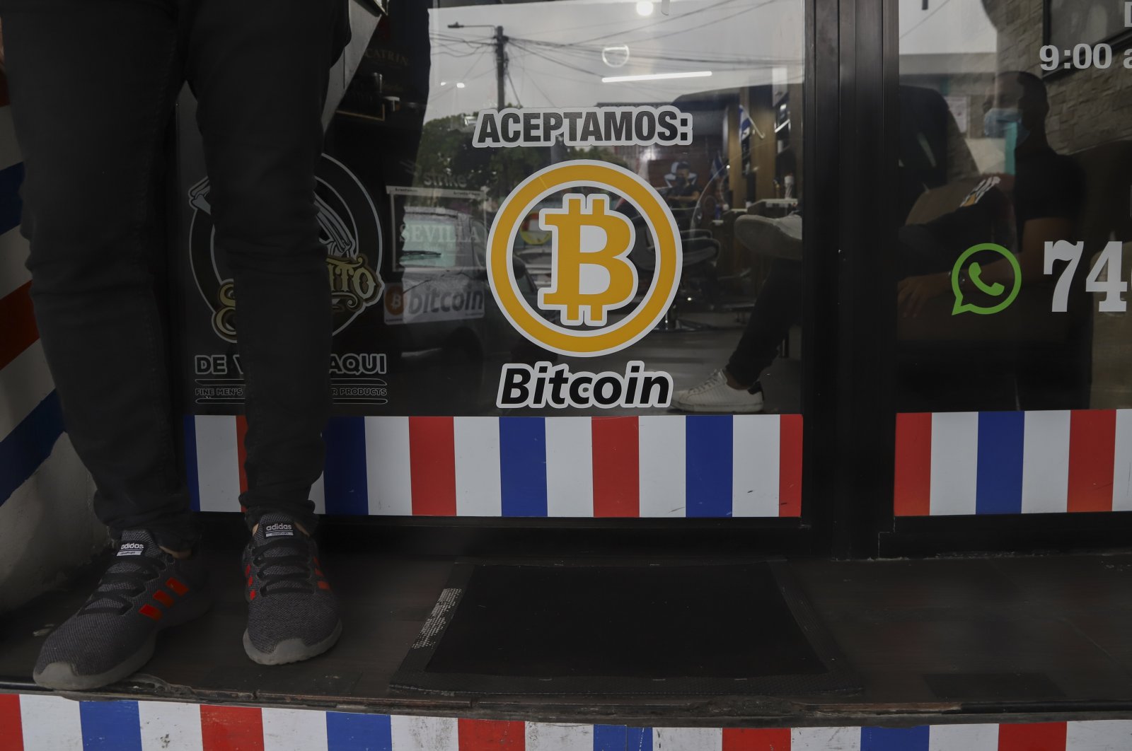 "We accept Bitcoin" is announced at a barber shop in Santa Tecla, El Salvador, Sept. 4, 2021. (AP Photo)