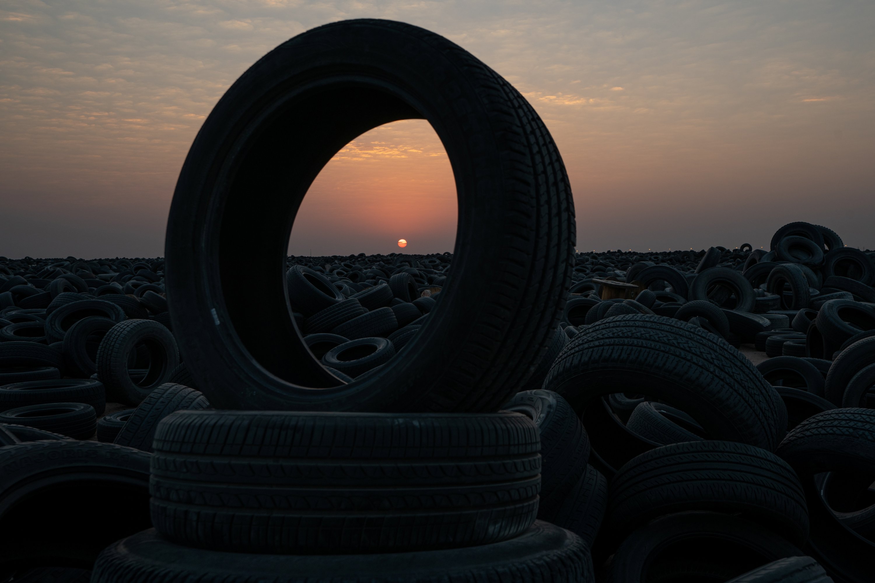 The sun sets at the tire recycling factory where millions of tires wait to be recycled in Salmi, Kuwait, Sept. 4, 2021. (Reuters Photo)