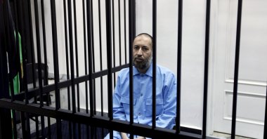 Saadi Gadhafi, son of Moammar Gadhafi, sits behind bars during a hearing at a courtroom in Tripoli, Libya, Feb. 7, 2016. (Reuters File Photo)