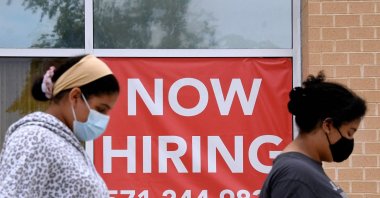 Women walk past by a "Now Hiring" sign outside a store in Arlington, Virginia, U.S., Aug. 16, 2021. (AFP Photo)