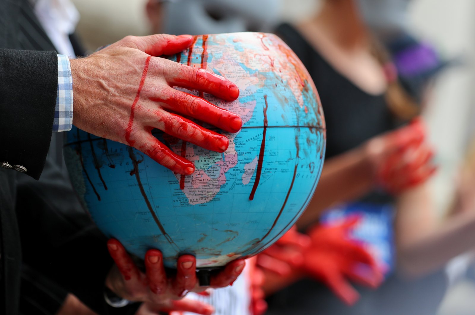 An Extinction Rebellion climate activist holds a globe stained with fake blood during a protest outside the Bank of England, in London, Britain Aug. 27, 2021. (Reuters Photo)