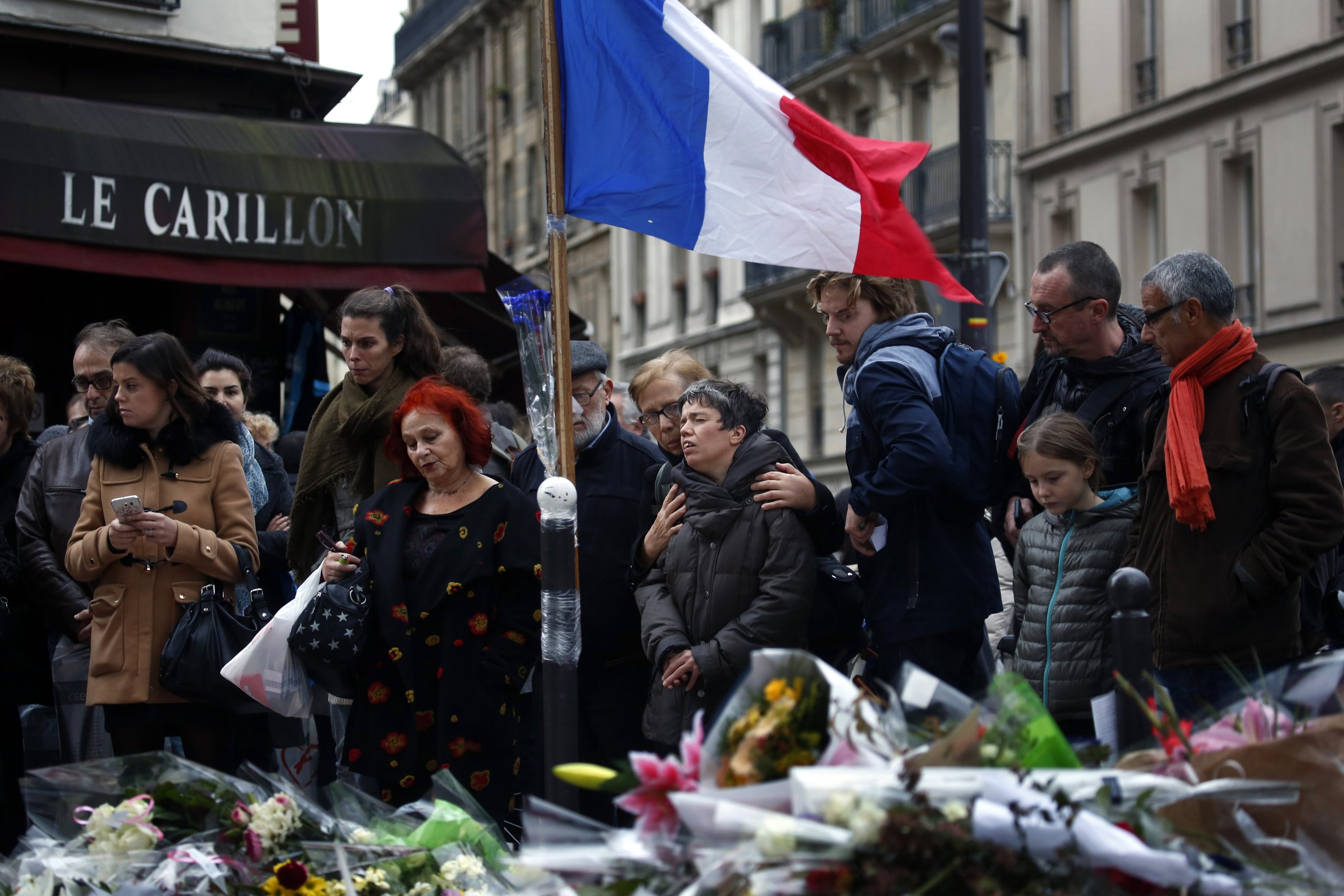 People gather in front of Le Carillon cafe, a site of the attacks, in Paris, France, Nov. 16, 2015. (AP Photo)