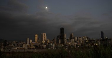 The moon rises over the capital city of Beirut as it remains in darkness during a power outage, Lebanon, Aug. 19, 2021. (AP Photo)