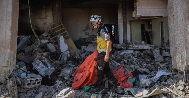 A member of the White Helmets inspects the damage at the group's center after it was targeted by warplanes in Idlib, Syria. (Getty Images)