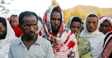 Men stand in line to receive food donations, at the Tsehaye primary school, which was turned into a temporary shelter for people displaced by conflict, in the town of Shire, Tigray region, Ethiopia, March 15, 2021. (Reuters Photo)
