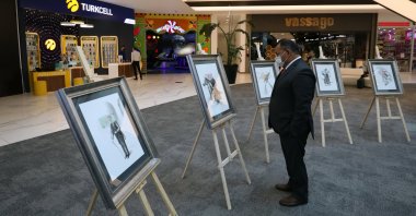 A visitor examines works by Fernando Valdiviezo at the exhibition, Ankara, Turkey, Sept. 8, 2021. (AA Photo) 
