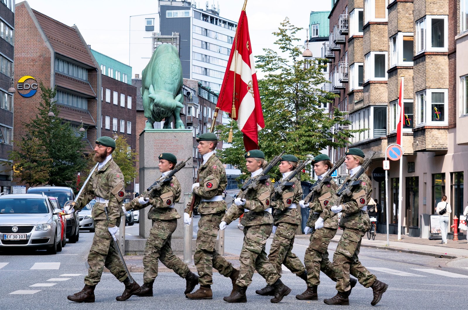 Officers carry Danish flags past The Cimbrer Bull during the official Flag Day in honor of Denmark's deployed soldiers through the ages, in Aalborg, Denmark, Sept. 5, 2021. (Reuters Photo)