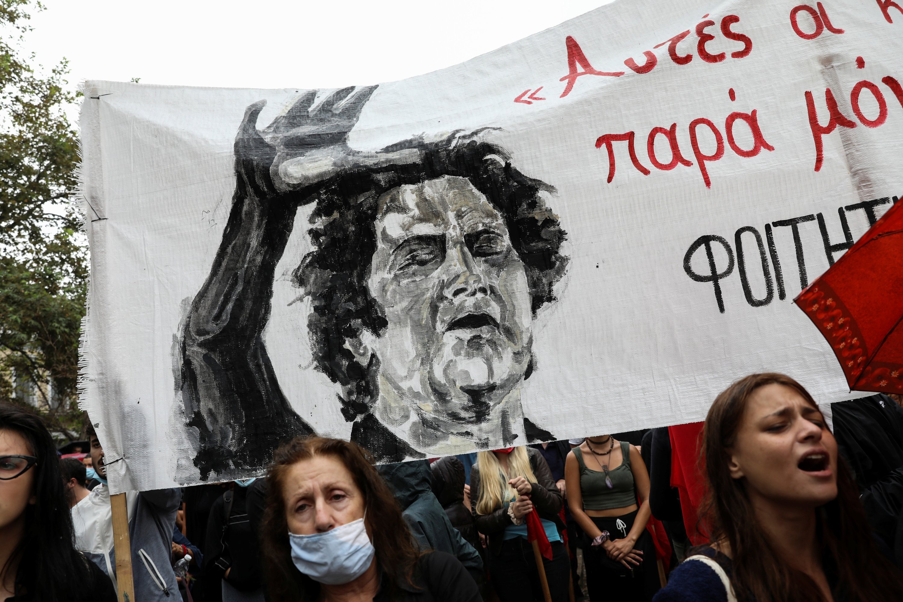 People sing in front of a banner depicting deceased Greek composer Mikis Theodorakis during a farewell ceremony for the composer outside the Metropolitan Cathedral of Athens, Greece, Sept. 8, 2021. (Reuters Photo)