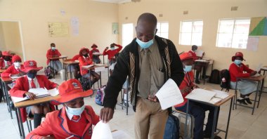 A teacher distributes examination papers to students at the Oceanwaves Junior School just outside Harare, Zimbabwe, Aug. 30, 2021. (EPA Photo)