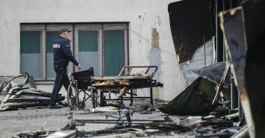 A police officer walks past burned hospital equipment on the site of a destroyed field hospital following a fire in Tetovo, North Macedonia, Sept. 9, 2021. (AP Photo)