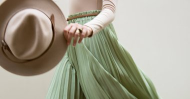 One way to wear a pleated skirt is in combination with an oversized top piece. (Shutterstock Photo)