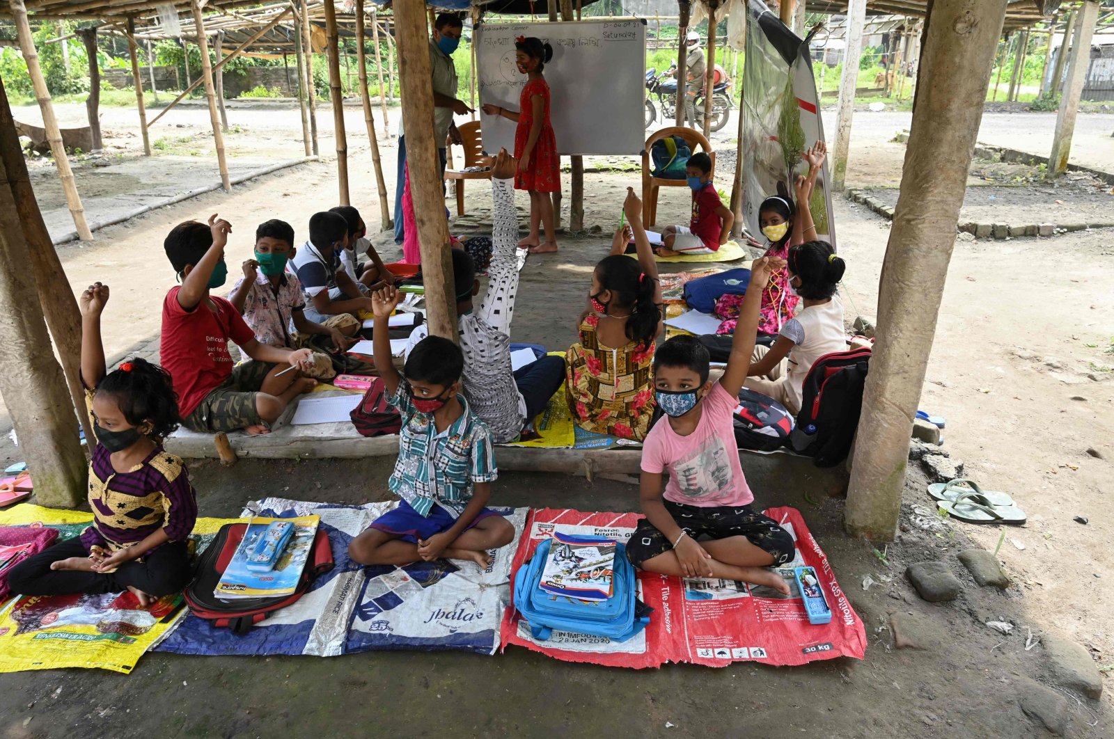 Children attend a class organized by a nongovernmental organization (NGO) as schools remain closed in West Bengal state due to COVID-19 restrictions, at a temporary market site on the outskirts of Kolkata, India, Sept. 4, 2021. (AFP Photo)