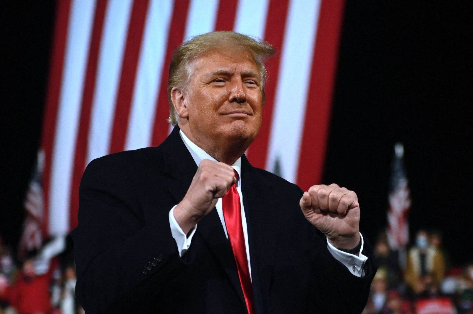 Then U.S. President Donald Trump holds up his fists at the end of a rally to support Republican Senate candidates at Valdosta Regional Airport in Valdosta, Georgia, Dec. 5, 2020. (AFP Photo)