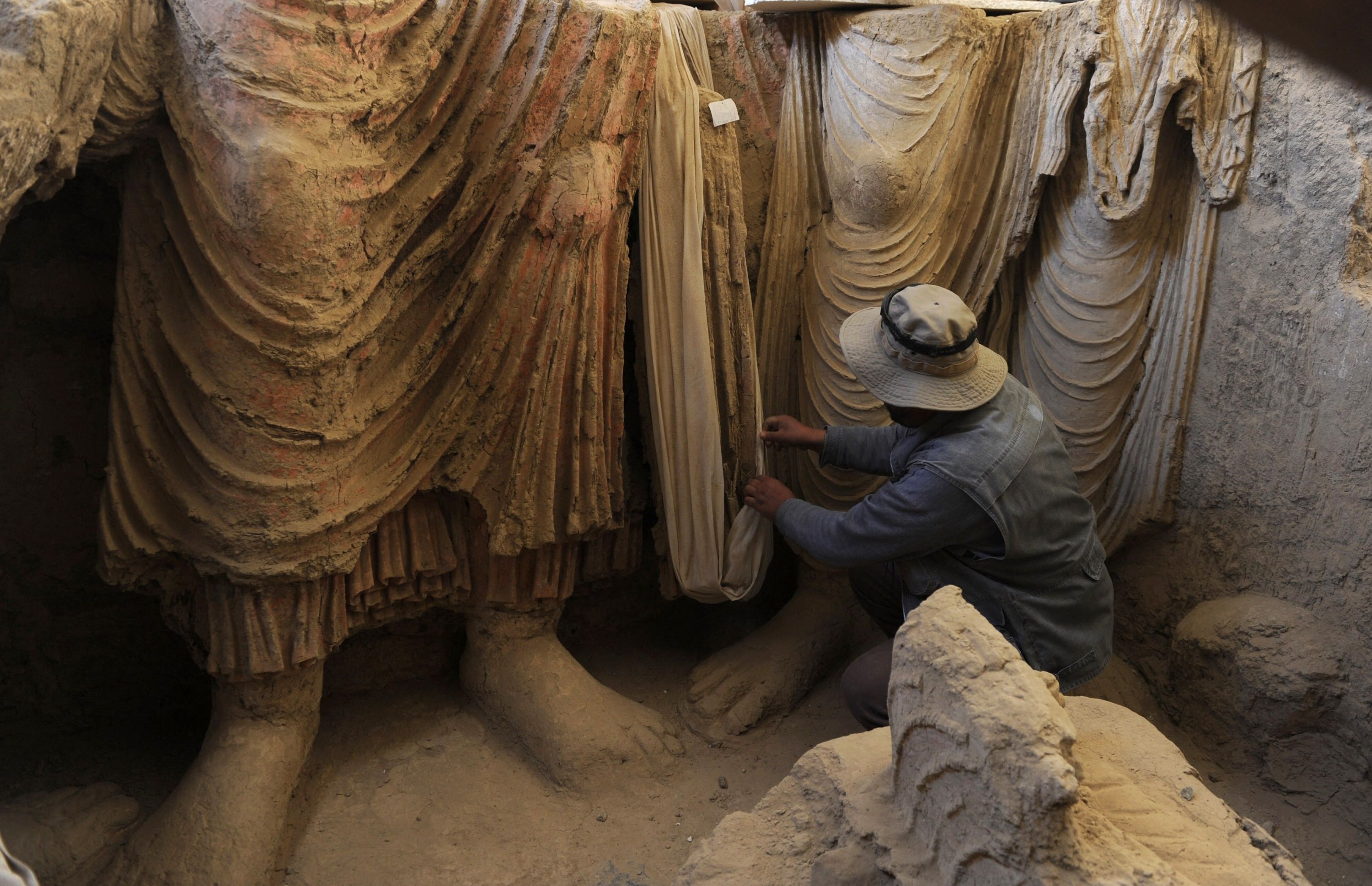 An Afghan archaeologist examines the remains of Buddha statues discovered inside an ancient monastery in Mes Aynak, in the eastern province of Logar, Afghanistan, Nov. 23, 2010. (AFP Photo)