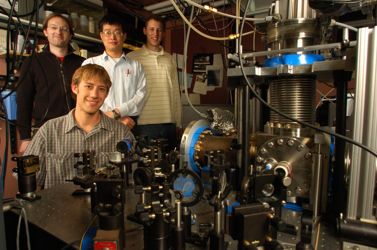 Florian Adler (L), Jun Ye (C), Matthew Kirchner (R) and seated Michael Thorpe pose in front of their optical frequency comb molecule detection system at the University of Colorado, in Boulder, Colorado, U.S. (Getty Images)