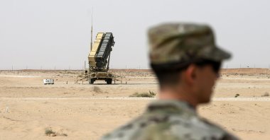 A member of the U.S. Air Force stands near a Patriot missile battery at Prince Sultan Air Base in Saudi Arabia, Feb. 20, 2020. (Pool via AP)