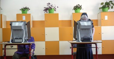Bulgarians cast their vote in a voting machine during parliamentary elections in the town of Bankya near the capital Sofia, Bulgaria, Sunday, July 11, 2021. (AP File Photo)