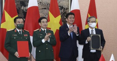 Vietnamese Defense Minister Phan Van Giang, center left, and Japanese Defense Minister Nobuo Kishi, center right, stand for photo with their officials after signing an agreement in Hanoi, Vietnam, Sept. 12, 2021. (AP Photo)