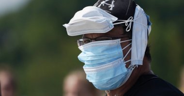 A person wears multiple face coverings during the pandemic-delayed State of Maine Bicentennial Parade, in Lewiston, Maine, U.S., Aug. 21, 2021. (AP Photo)