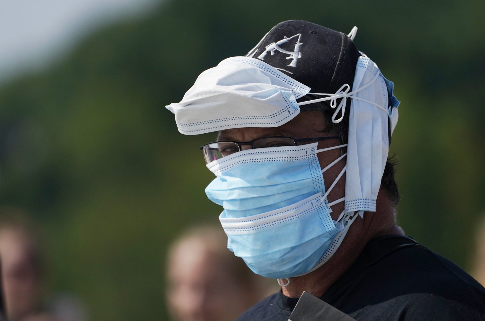 A person wears multiple face coverings during the pandemic-delayed State of Maine Bicentennial Parade, in Lewiston, Maine, U.S., Aug. 21, 2021. (AP Photo)