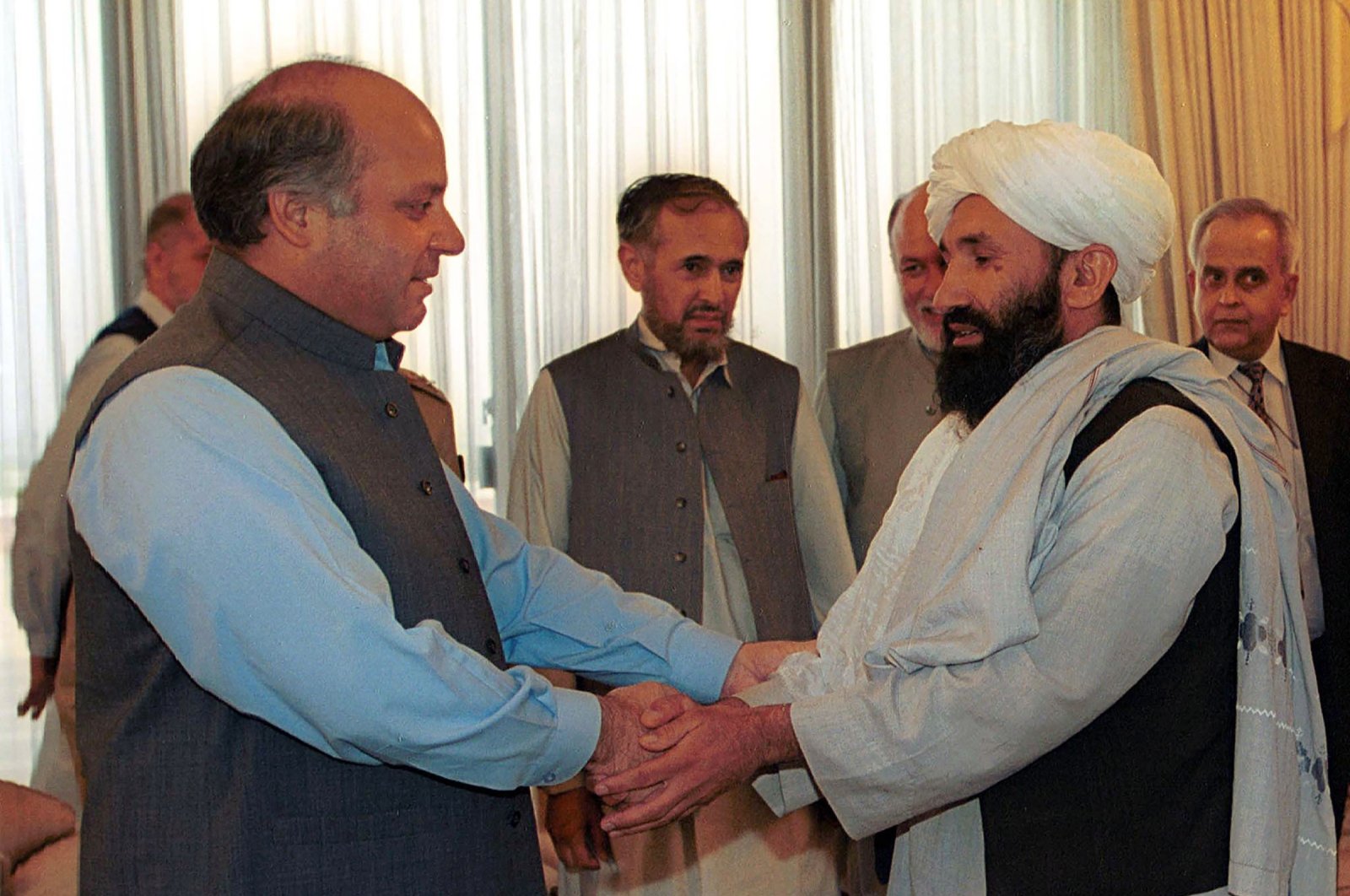Mullah Mohammad Hasan Akhund (R), Afghanistan's then-foreign minister, is received by Pakistani then-Prime Minister Nawaz Sharif, in Islamabad, Pakistan, Aug. 25, 1999. (AP File Photo)