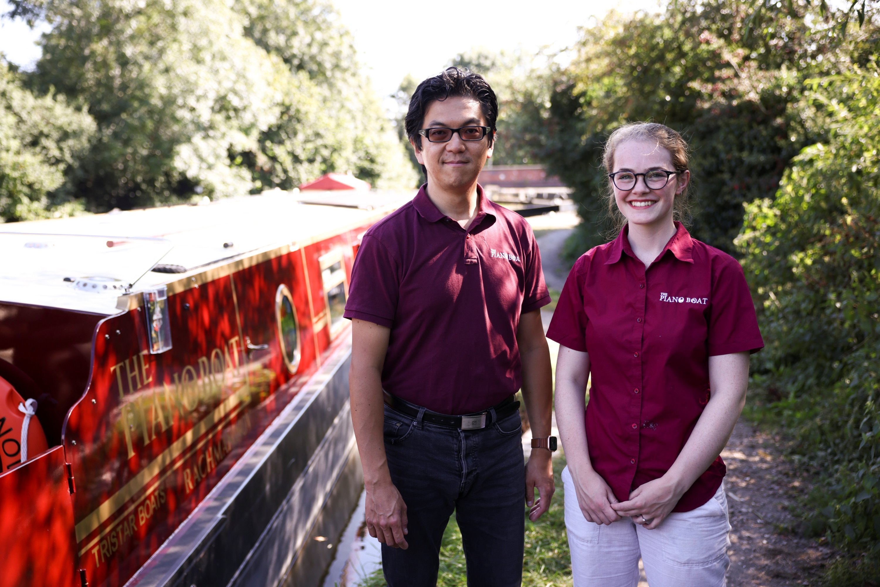 Pianists Masayuki Tayama and Rhiana Henderson stand next to their canal boat concert hall, named The Piano Boat, in Harefield, Britain, Sept. 8, 2021. (Reuters Photo)