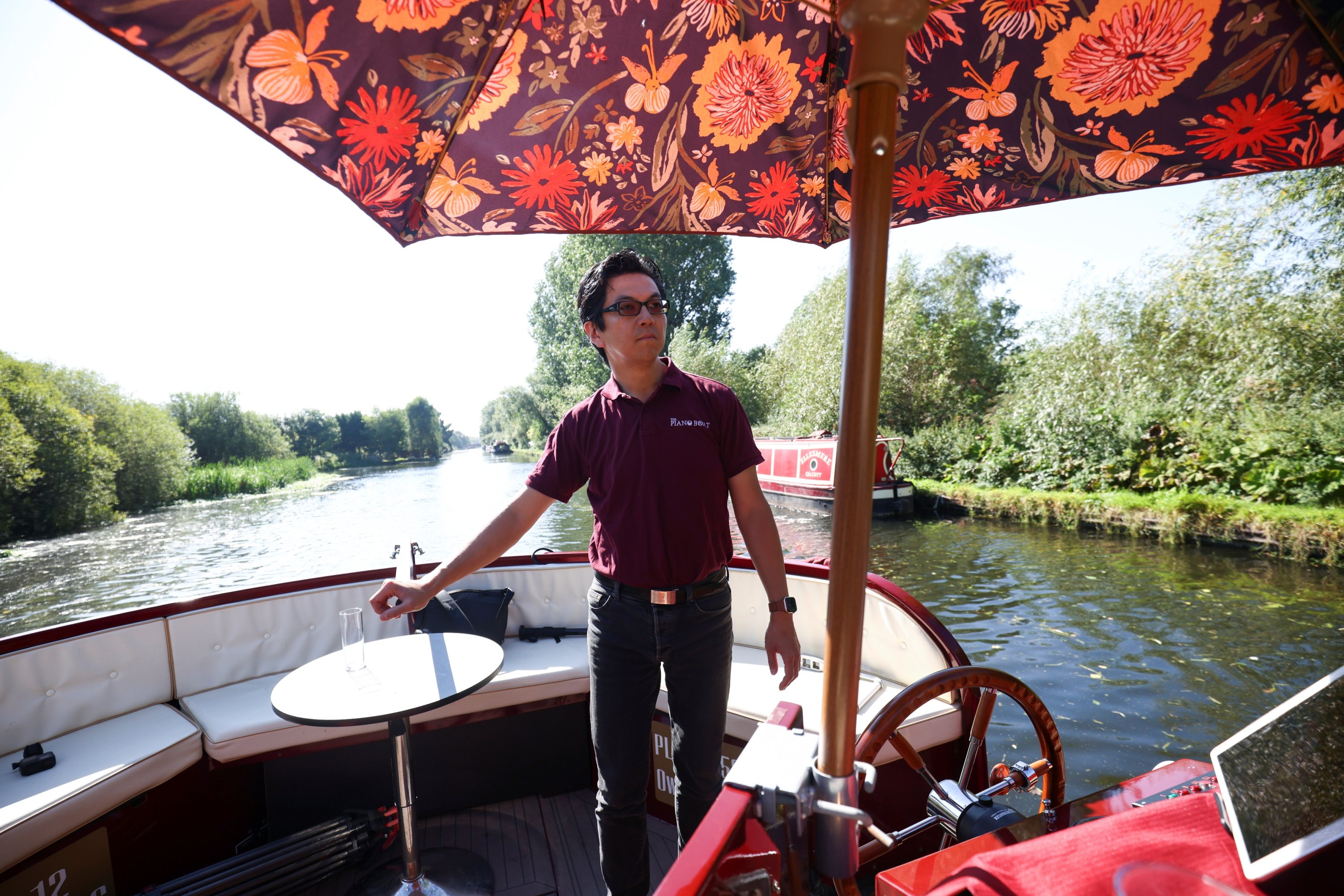 Pianist Masayuki Tayama steers his canal boat concert hall, named The Piano Boat, along the Colne Valley Canal in Harefield, Britain, Sept. 8, 2021. (Reuters Photo)